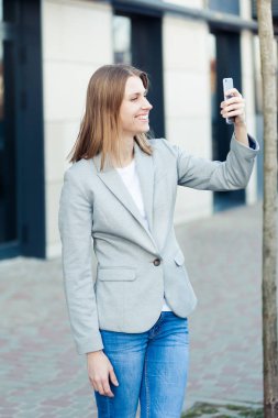 Güzel genç işkadını Smartphone kullanarak