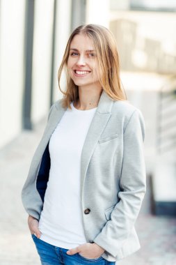 Ofis şirket yakınındaki güzel gülümseyen sarışın genç kadın portresi