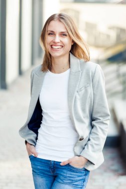 Ofis şirket yakınındaki güzel gülümseyen sarışın genç kadın portresi