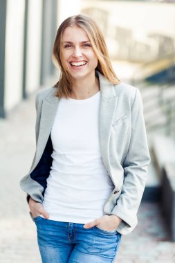 Ofis şirket yakınındaki güzel gülümseyen sarışın genç kadın portresi