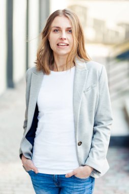 Ofis şirket yakınındaki güzel gülümseyen sarışın genç kadın portresi