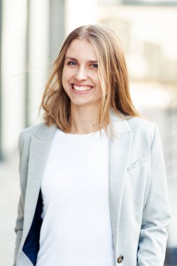 Ofis şirket yakınındaki güzel gülümseyen sarışın genç kadın portresi