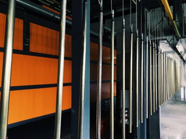 Metal parçalar için fabrikada endüstriyel konveyör hattı. Parça yüzeyinin ve boya parçalarının toz boya ile ön işlemesi.