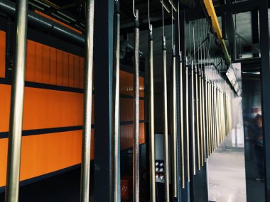 Metal parçalar için fabrikada endüstriyel konveyör hattı. Parça yüzeyinin ve boya parçalarının toz boya ile ön işlemesi.