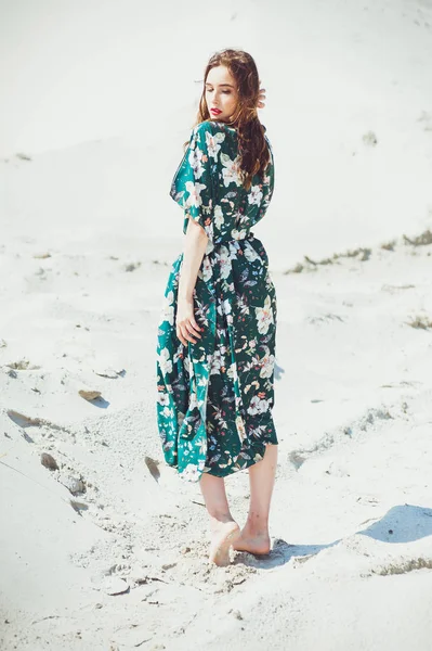 stock image Attractive slender girl in green swimwear posing on white sand beach. Young woman in bikin rests on vacation at sandy ocean shore. Concept travel, swimsuit