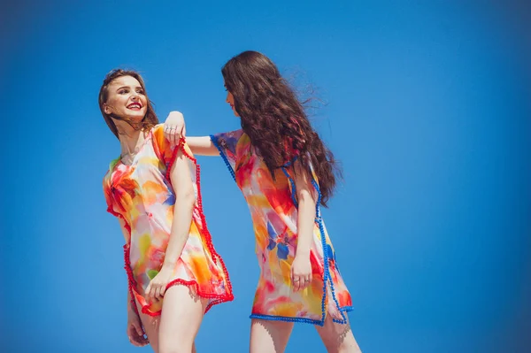 stock image Two gorgeous young women wearing swimmwear, blue sky background