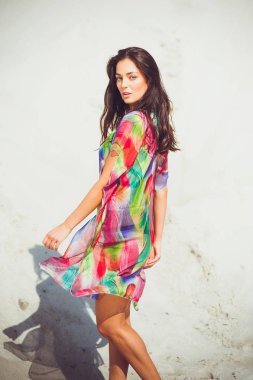 Renkli mayo kum üzerinde güzel genç şehvetli kadın