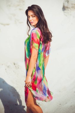 Renkli mayo kum üzerinde güzel genç şehvetli kadın