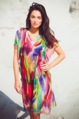 Renkli mayo kum üzerinde güzel genç şehvetli kadın