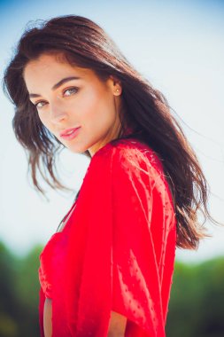 Kumda poz veren güzel bir kadın. Yaz modası kırmızı mayo.