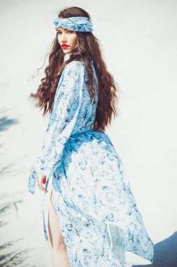 Kız çölde yürüyor. Güzel kadın yürüyor, kum veya kumul üzerinde staing. Moda mayo