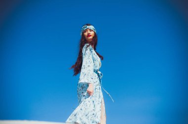 Kız çölde yürüyor. Güzel kadın yürüyor, kum veya kumul üzerinde staing. Moda mayo
