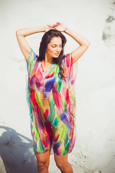 Beautiful young sensual woman on the sand in colorful swimwear