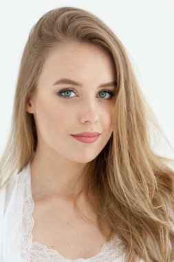 Sarışın ve güzel yüzlü gülümseyen güzel bir kadın. İnce vücutlu, doğal saç stili ve açık renk iç çamaşırlı mutlu sarışın kızın portresi..