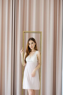 İç çamaşırı giymiş güzel genç bir kadın evde dinleniyor.