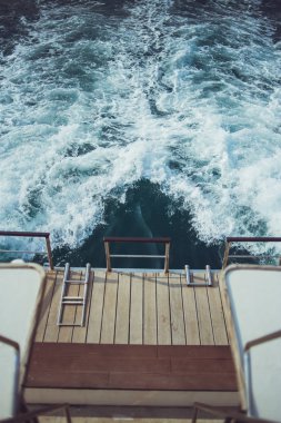 Denizde bir yelkenli geminin arkasında beyaz dalgalar