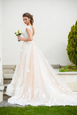 Gelinliği uzun, gelinliği buketli güzel gelin.