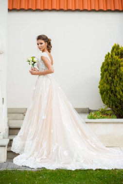 Gelinliği uzun, gelinliği buketli güzel gelin.