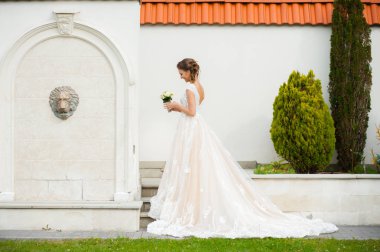 Gelinliği uzun, gelinliği buketli güzel gelin.