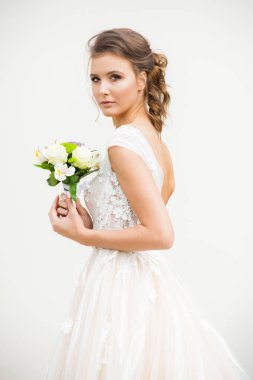 Gelinliği uzun, gelinliği buketli güzel gelin.