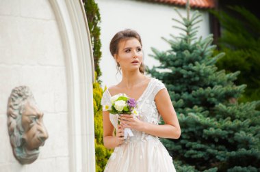 Gelinliği uzun, gelinliği buketli güzel gelin.