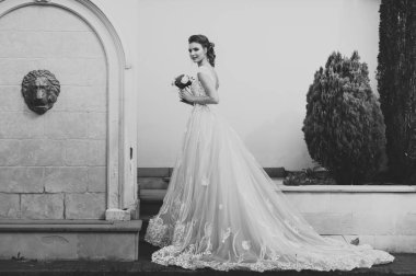 Düğün seremonisinden önce beyaz sarayın yakınında açık renkli, uzun beyaz elbiseli zarif bir kadın yürüyordu..