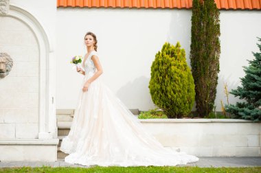 Düğün seremonisinden önce beyaz sarayın yakınında açık renkli, uzun beyaz elbiseli zarif bir kadın yürüyordu..