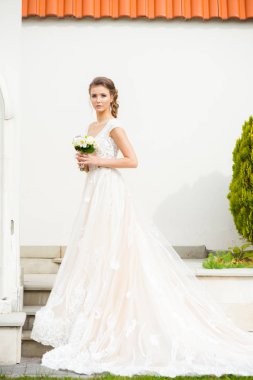 Düğün seremonisinden önce beyaz sarayın yakınında açık renkli, uzun beyaz elbiseli zarif bir kadın yürüyordu..