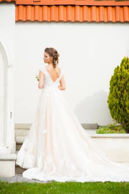 Düğün seremonisinden önce beyaz sarayın yakınında açık renkli, uzun beyaz elbiseli zarif bir kadın yürüyordu..