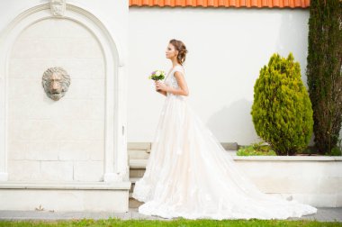 Düğün seremonisinden önce beyaz sarayın yakınında açık renkli, uzun beyaz elbiseli zarif bir kadın yürüyordu..