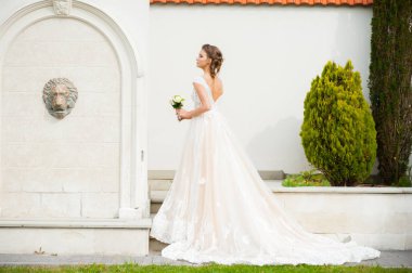 Düğün seremonisinden önce beyaz sarayın yakınında açık renkli, uzun beyaz elbiseli zarif bir kadın yürüyordu..