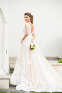 Düğün seremonisinden önce beyaz sarayın yakınında açık renkli, uzun beyaz elbiseli zarif bir kadın yürüyordu..