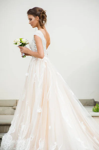 結婚式の花束と長いウェディングドレスの美しい花嫁 — ストック写真
