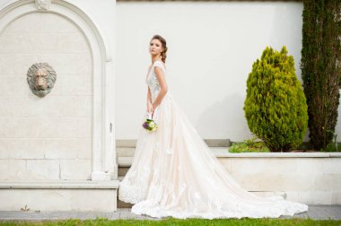 Düğün seremonisinden önce beyaz sarayın yakınında açık renkli, uzun beyaz elbiseli zarif bir kadın yürüyordu..