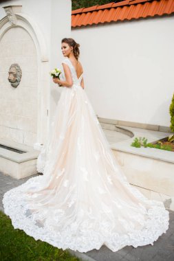 Düğün seremonisinden önce beyaz sarayın yakınında açık renkli, uzun beyaz elbiseli zarif bir kadın yürüyordu..