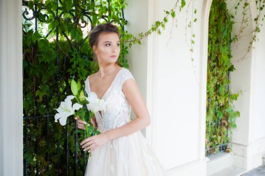 Düğün seremonisinden önce beyaz sarayın yakınında açık renkli, uzun beyaz elbiseli zarif bir kadın yürüyordu..