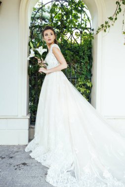 Düğün seremonisinden önce beyaz sarayın yakınında açık renkli, uzun beyaz elbiseli zarif bir kadın yürüyordu..