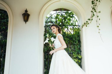 Düğün seremonisinden önce beyaz sarayın yakınında açık renkli, uzun beyaz elbiseli zarif bir kadın yürüyordu..