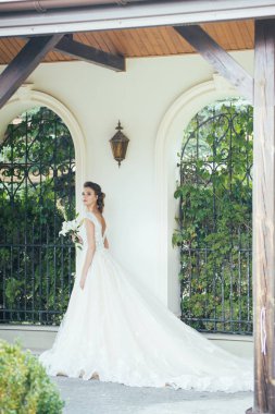 Düğün seremonisinden önce beyaz sarayın yakınında açık renkli, uzun beyaz elbiseli zarif bir kadın yürüyordu..