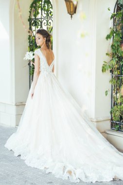 Düğün seremonisinden önce beyaz sarayın yakınında açık renkli, uzun beyaz elbiseli zarif bir kadın yürüyordu..