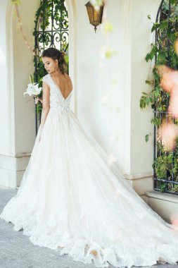 Düğün seremonisinden önce beyaz sarayın yakınında açık renkli, uzun beyaz elbiseli zarif bir kadın yürüyordu..