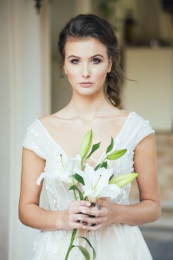 Düğün seremonisinden önce beyaz sarayın yakınında açık renkli, uzun beyaz elbiseli zarif bir kadın yürüyordu..