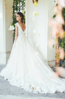 Düğün seremonisinden önce beyaz sarayın yakınında açık renkli, uzun beyaz elbiseli zarif bir kadın yürüyordu..