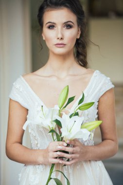 Düğün seremonisinden önce beyaz sarayın yakınında açık renkli, uzun beyaz elbiseli zarif bir kadın yürüyordu..