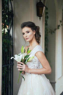 Düğün seremonisinden önce beyaz sarayın yakınında açık renkli, uzun beyaz elbiseli zarif bir kadın yürüyordu..