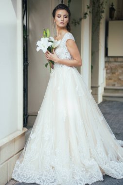 Düğün seremonisinden önce beyaz sarayın yakınında açık renkli, uzun beyaz elbiseli zarif bir kadın yürüyordu..