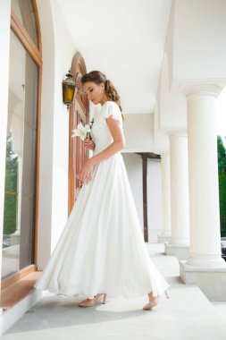 Düğün seremonisinden önce beyaz sarayın yakınında açık renkli, uzun beyaz elbiseli zarif bir kadın yürüyordu..