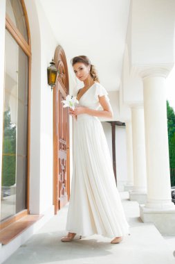 Düğün seremonisinden önce beyaz sarayın yakınında açık renkli, uzun beyaz elbiseli zarif bir kadın yürüyordu..