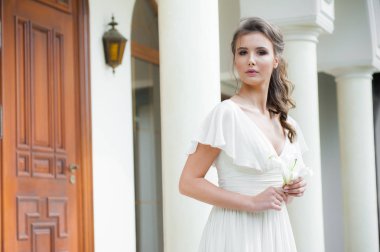 Düğün seremonisinden önce beyaz sarayın yakınında açık renkli, uzun beyaz elbiseli zarif bir kadın yürüyordu..