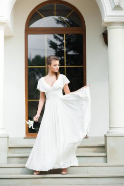 Düğün seremonisinden önce beyaz sarayın yakınında açık renkli, uzun beyaz elbiseli zarif bir kadın yürüyordu..